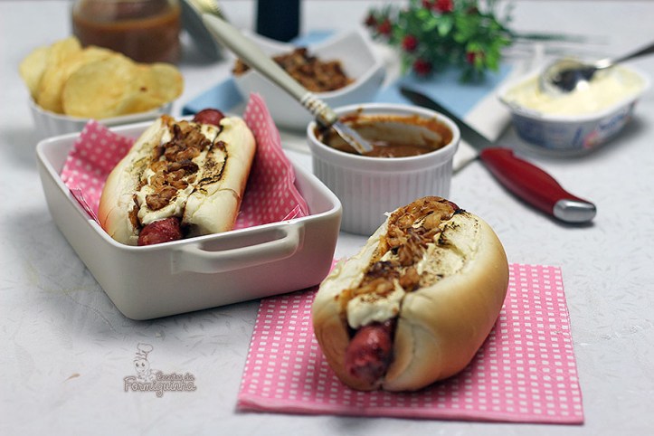 Sanduíche estilo food truck feito com linguiça defumada, molho barbecue de tomate pelado, cream cheese maçaricado no pão de cachorro-quente com cebola crocante (crispy).